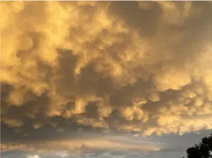 Golden clouds in blue sky at sunset.